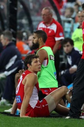 Kurt Tippett talks to Sydney Swans doctor Nathan Gibbs after he was forced to leave the field.