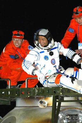 Chinese astronaut Nie Haisheng is helped out of the re-entry capsule of China's second manned spacecraft, Shenzhou VI, in 2005.