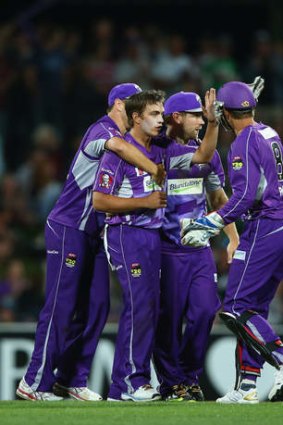 Cameron Boyce of the Hurricanes celebrates with team mates after taking the wicket of Ben Cutting of the Heat.