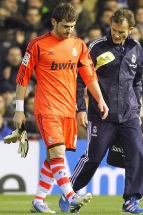 Iker Casillas leaves the pitch after injuring his hand.