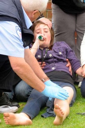 A young girl is treated by paramedics.
