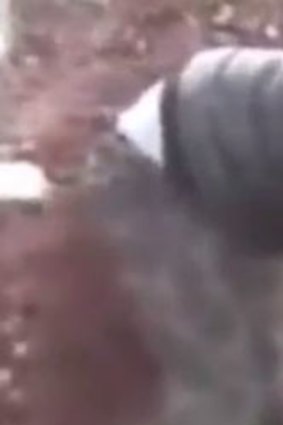 Still image of video of Khaled al-Hamad cutting heart and organs out of dead Syrian soldier.