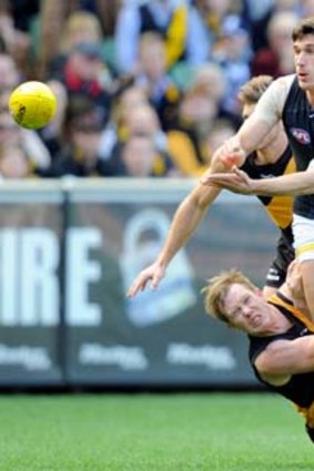 Rock-solid: Carlton defender Michael Jamison clears the ball despite the efforts of Tiger Jack Riewoldt last weekend.
