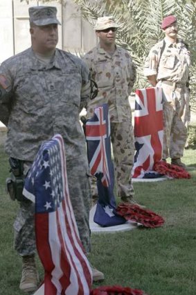 American, Australian, and British soldiers stand beside their national flags during a Remembrance Day ceremony at the U.S. embassy compound in the fortified Green Zone in Baghdad, November 11, 2006.