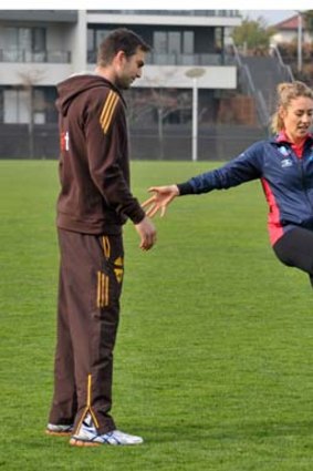 Elissa Kent nee Macleod, seen here getting a spot of AFL training, is expecting her first child in August.