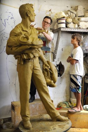 Queensland schoolboy Ronan Robinson watches Melbourne sculptor William Eicholtz put the finishing touches.