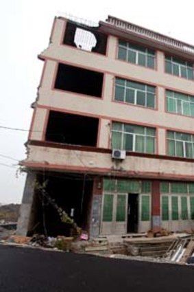 Landmark building &#8230; Luo Baogen shows his land certificate. He and his wife refuse to move from an apartment block that now sits in the middle of a newly built road in Wenling in China.