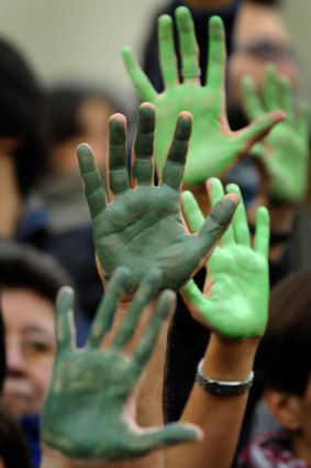 Protesters paint their hands green at a rally for climate change in Spain.