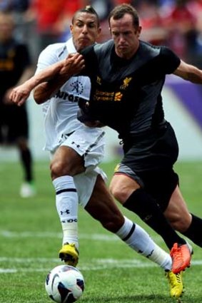 Charlie Adam of Liverpool is pulled down by Jake Livermore of Tottenham Hotspur during the first half of the friendly at M&T Bank Stadium in Baltimore, Maryland.