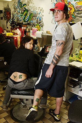 Ink-riminating evidence ... Toni Fan and Brett Gould show the tattoos they got to win free snowboards.