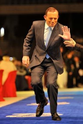 At the 2013 AFL Grand Final Breakfast at Etihad Stadium, Prime Minister Tony Abbott enters on the blue carpet.