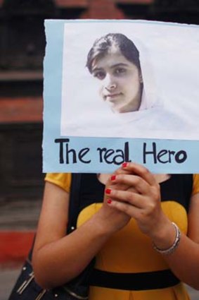 Global support ... a Nepalese student holds a photo of  Pakistani schoolgirl Malala Yousafzai, during a candlelight vigil.