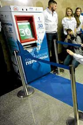 A young woman squats in front of a vending machine that sells the subway  tickets for squats instead of money during the machine's presentation at the Vystavochaya metro station in western Moscow.