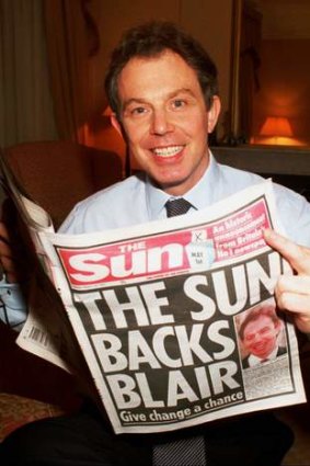 Tony Blair holds a copy of the Sun newspaper at his London home in 1997. Murdoch's support for Blair proved crucial in his election victories.