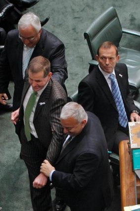 ALP MPs Daryl Melham and Michael Danby drag Mr Slipper to the Speaker's chair past a stony faced Tony Abbott.