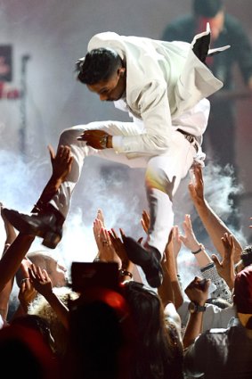 Crushing moment ... Singer Miguel leaping across the crowd during his performance at the Billboard Music Awards.