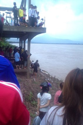 Residents gather as debris from the plane washes ashore.