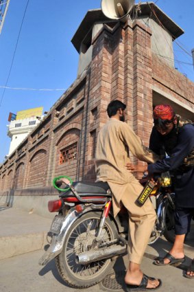 A Pakistani security guard searches a man  during a press conference by Hafiz Saeed in Lahore.