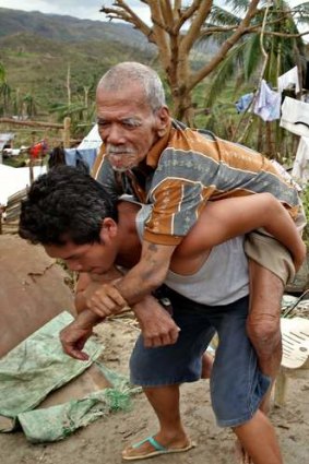 Miracle: Joel Asoque carries his blind grandfather.