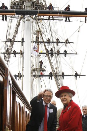 Queen Elizabeth II walks on deck with Richard Doughty, director of the Cutty Sark Trust.