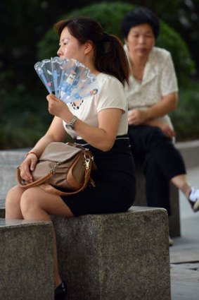 Boiling point: a woman uses a fan to keep cool as a heatwave continues in Shanghai.