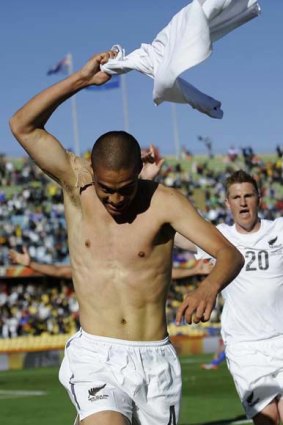 Reid strips off his shirt as he runs around in glee after scoring his country's first goal in the World Cup.