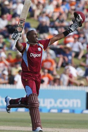 Dwayne Bravo waves to the crowd after reaching his century.