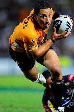 Benji Marshall of the Tigers skips out of a tackle of Ray Thompson of the Cowboys.