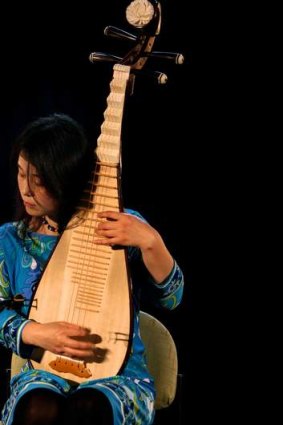 Wu Man rehearses on the pipa, a four-string Chinese lute.