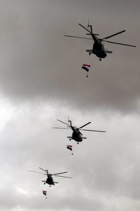 Syrian Army Mi-18 helicopters with national flags fly above demonstrators during a rally to support President Bashar al-Assad earlier this year.