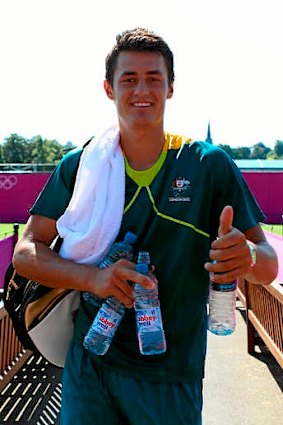 Bernard Tomic of Australia gives a thumbs up after a practice session with Lleyton Hewitt.