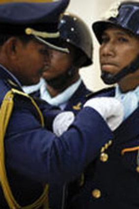 A Cambodian official adjusts uniform of a member of honor guards.