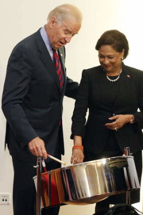 US Vice President Joe Biden, accompanied by Trinidad & Tobago's Prime Minister Kamla Persad-Bissessar, tries out a steelpan, the traditional percussion instrument of the Caribbean twin-island country, during their meeting in St Anns, Trinidad, on Tuesday.