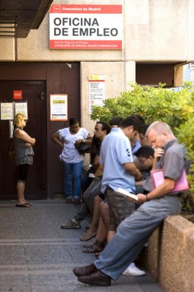 Unemployed workers wait outside a government job centre in Madrid.