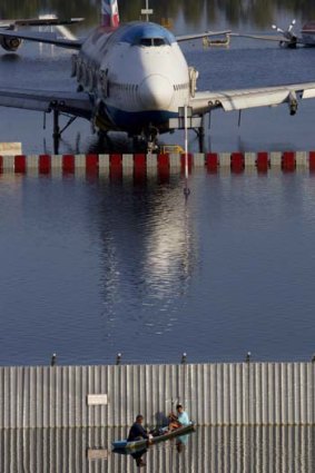Marooned ... a plane sits stranded on the flooded tarmac at Bangkok's Don Muang airport.