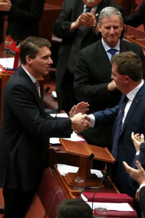 Liberal senator James McGrath is congratulated by fellow Liberal senator Cory Bernardi after delivering his first speech in the Senate.