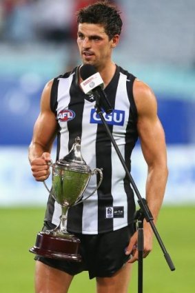 Scott Pendlebury is presented with the cup after the round two match between the Sydney Swans and Collingwood.