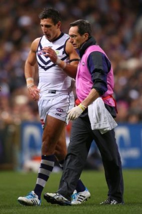 Matthew Pavlich is assisted from the field during the match between Fremantle and Carlton. 