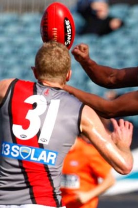 Port Adelaide's Paul Stewart handpasses while under pressure from Dustin Fletcher.