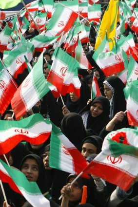 Iranian schoolgirls wave flags and anti-US placards at a rally to mark the anniversary of the Islamic revolution in Tehran.