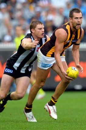 In control: Hawthorn skipper Luke Hodge looks to offload before being tackled by Heath Shaw.