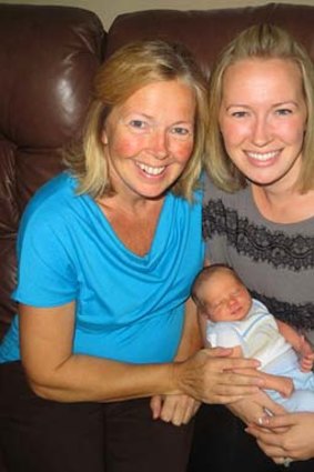 Madden Hebert rests with his mum, Angel Hebert, right, and his grandmother, Linda Sirois.