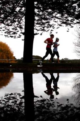 Slippery path ... joggers take to a gloomy Centennial Park in Sydney early yesterday.