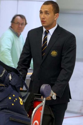 Suitable . . . a black-eyed Quade Cooper arrives in Sydney yesterday.