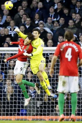 Tottenham Hotspur's 'keeper Hugo Lloris, punches the ball clear, colliding with Swansea City's Michu in the process.
