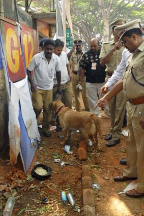 An Indian police officer and a bomb squad official inspect the site of explosion at Chinnaswamy Stadium in Bangalore.