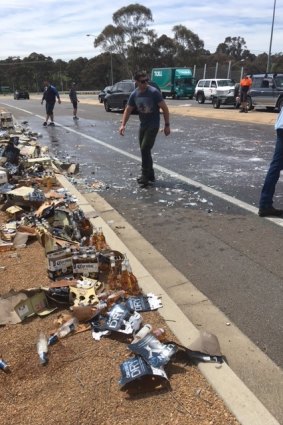Other motorists stopped to help clean up the glass which was strewn for metres after a ute lost its load of beer on the Cotter Road.