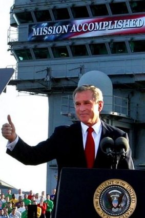 Former President George W Bush flashes a thumbs-up after famously declaring the end of major combat in Iraq in 2003.