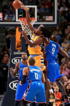 Kenneth Faried (35) of the Denver Nuggets grabs a rebound away from Serge Ibaka (9), Kevin Durant, and Russell Westbrook (0) of the Oklahoma City Thunder.