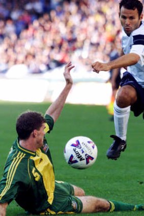 Back for more: Ryan Giggs jumps over Australia's Alex Tobin during a 1999 match in Sydney.